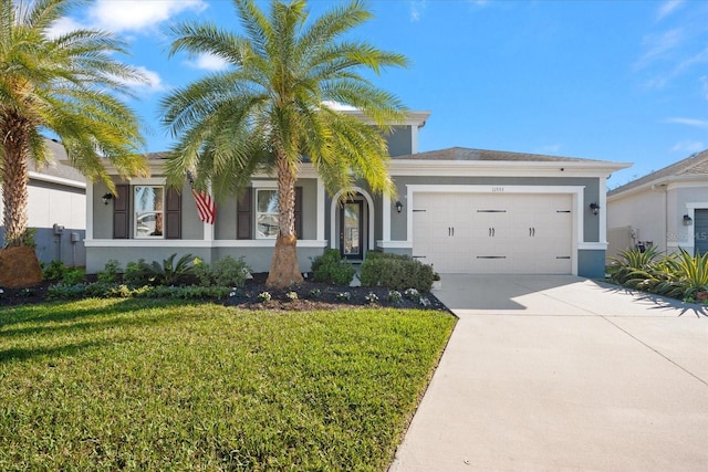 view of front facade featuring driveway, a front lawn, an attached garage, and stucco siding