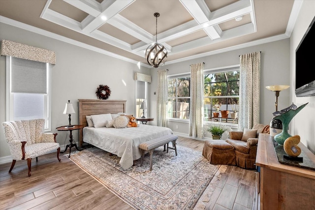 bedroom with a chandelier, ornamental molding, light wood-type flooring, and coffered ceiling