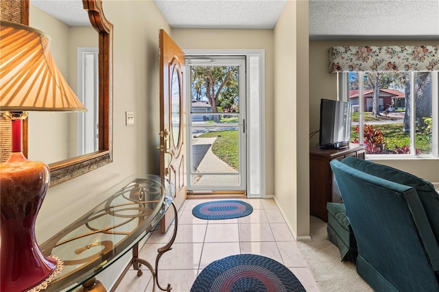 entrance foyer with a textured ceiling, light tile patterned flooring, and baseboards