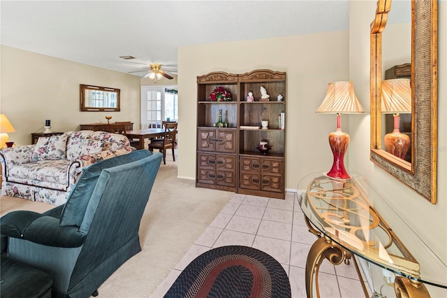 living room featuring a ceiling fan, carpet flooring, a textured ceiling, tile patterned flooring, and baseboards