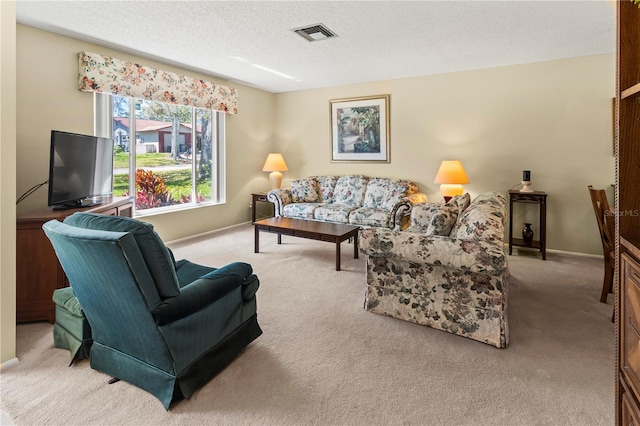 living area featuring baseboards, visible vents, a textured ceiling, and carpet flooring