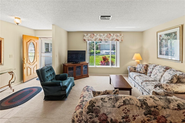 tiled living area with visible vents and a textured ceiling