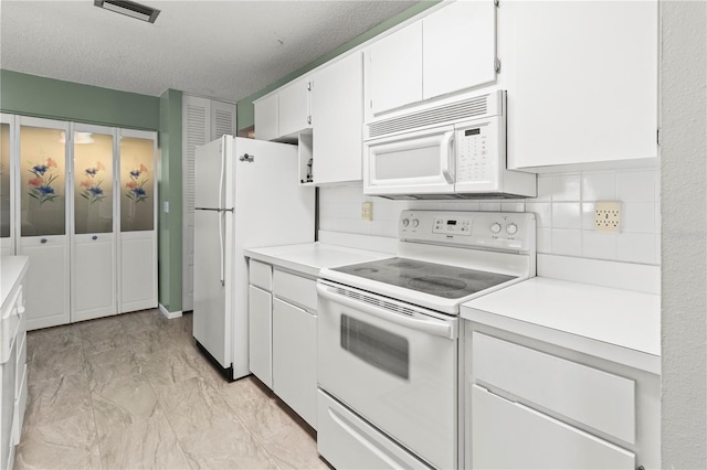 kitchen featuring light countertops, white appliances, decorative backsplash, and white cabinets