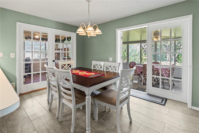 dining area with french doors and a notable chandelier