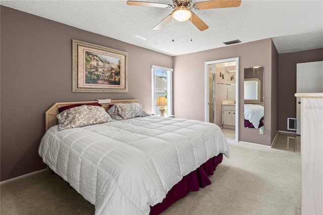 bedroom featuring baseboards, visible vents, a textured ceiling, and light colored carpet