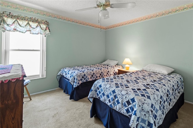 carpeted bedroom with a ceiling fan, baseboards, and a textured ceiling