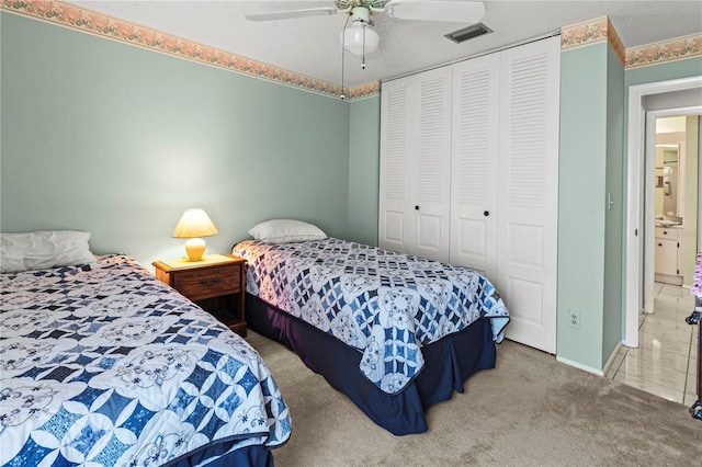 bedroom featuring a closet, carpet flooring, ceiling fan, and visible vents