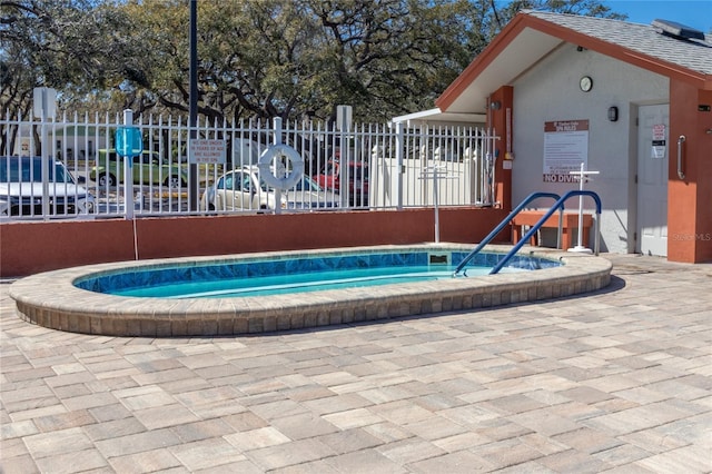 view of swimming pool featuring fence