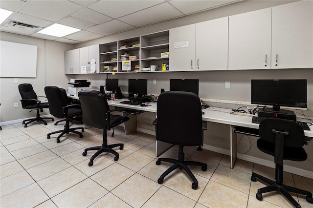 office space with light tile patterned floors, visible vents, a paneled ceiling, and baseboards