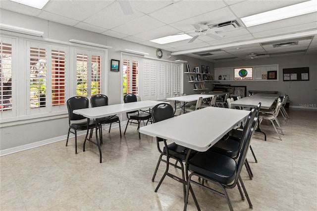 dining space featuring a ceiling fan, a paneled ceiling, visible vents, and baseboards