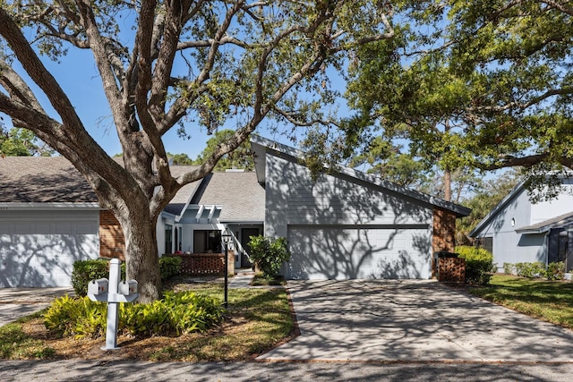 mid-century home featuring concrete driveway and an attached garage