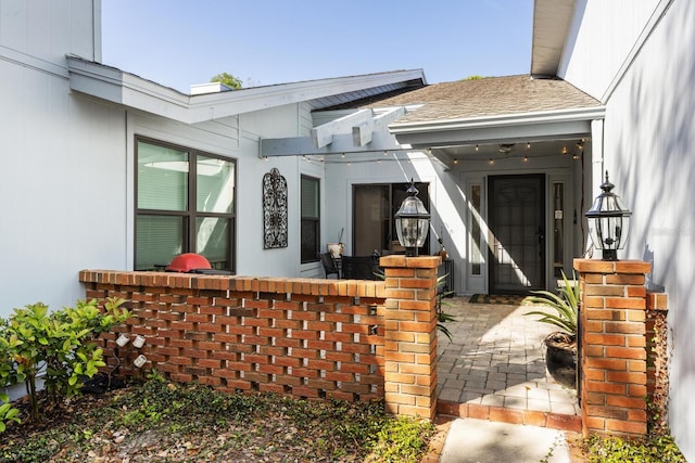 entrance to property with a shingled roof