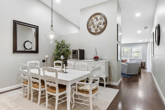 dining area with dark wood-style floors, visible vents, and baseboards