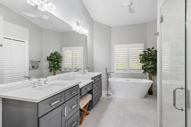 full bathroom featuring double vanity, a healthy amount of sunlight, a ceiling fan, and a sink