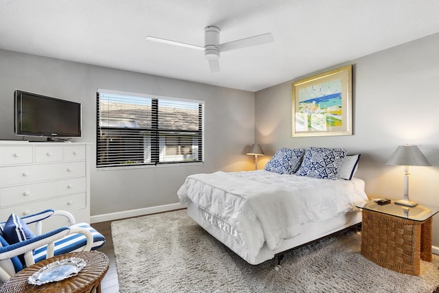 bedroom featuring wood finished floors, a ceiling fan, and baseboards