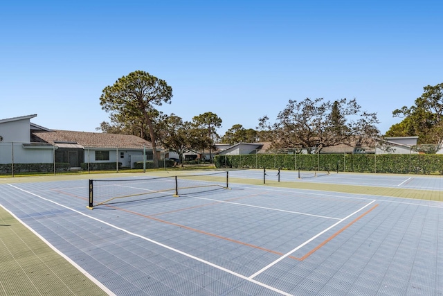 view of tennis court with community basketball court and fence