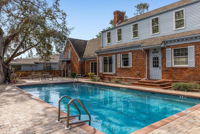 community pool featuring fence and a patio