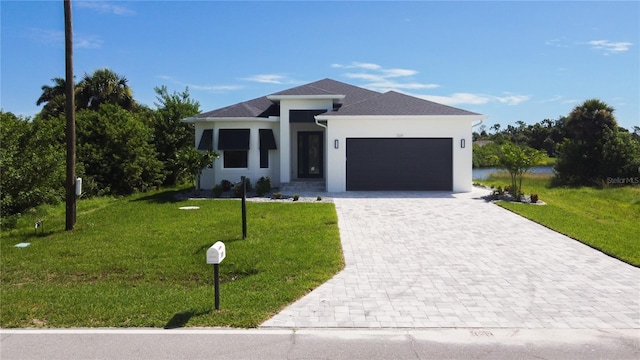 view of front of home with decorative driveway, an attached garage, stucco siding, and a front yard