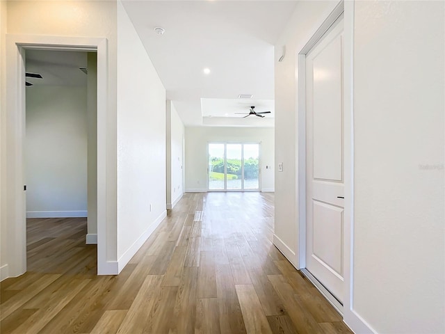 corridor with baseboards and wood finished floors