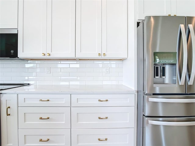 kitchen featuring tasteful backsplash, white cabinets, stainless steel fridge with ice dispenser, stove, and light stone countertops