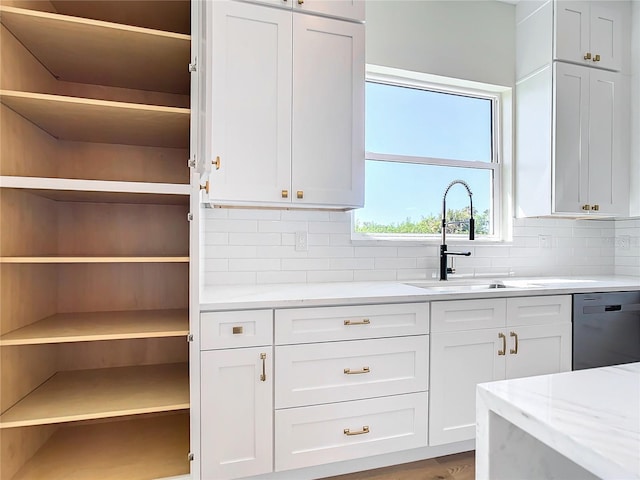 kitchen featuring white cabinets, dishwashing machine, a sink, open shelves, and backsplash