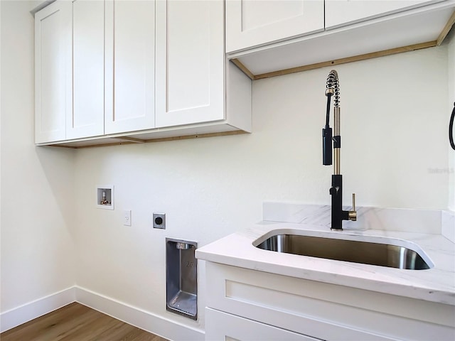 laundry room featuring hookup for a washing machine, a sink, baseboards, cabinet space, and electric dryer hookup