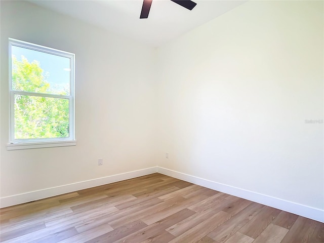 spare room with light wood-style floors, ceiling fan, and baseboards