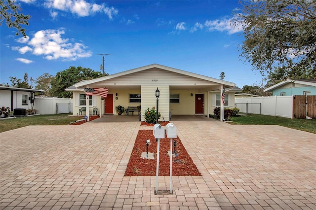 rear view of house with central air condition unit, decorative driveway, fence, and a gate