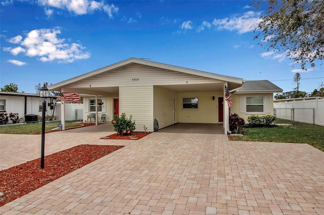 ranch-style home featuring decorative driveway, central AC, and fence