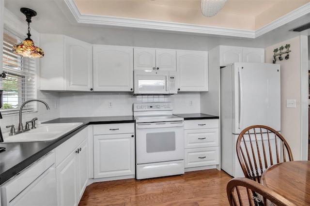 kitchen with light wood-style flooring, a sink, dark countertops, white cabinetry, and white appliances