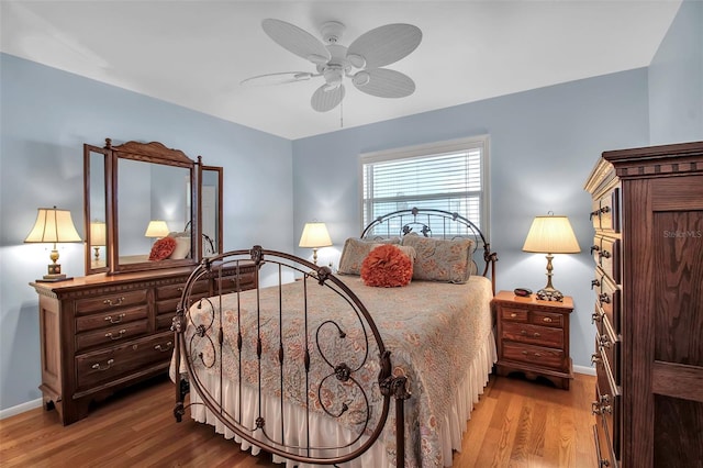 bedroom featuring a ceiling fan, wood finished floors, and baseboards