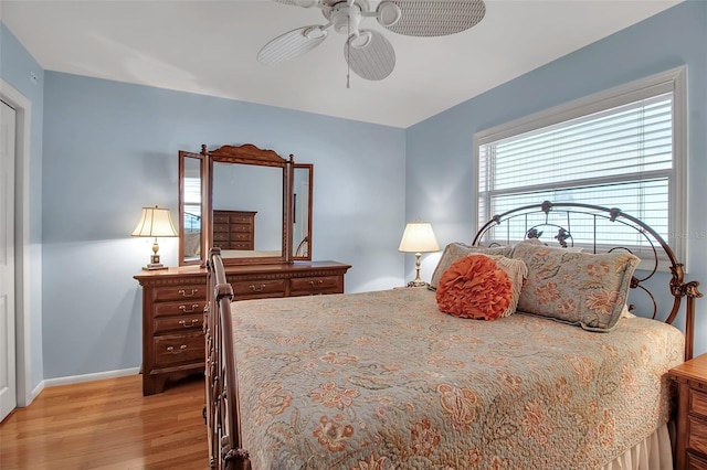 bedroom featuring baseboards, a ceiling fan, and light wood finished floors