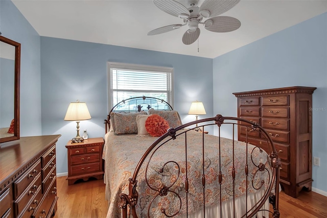 bedroom featuring a ceiling fan, baseboards, and light wood finished floors