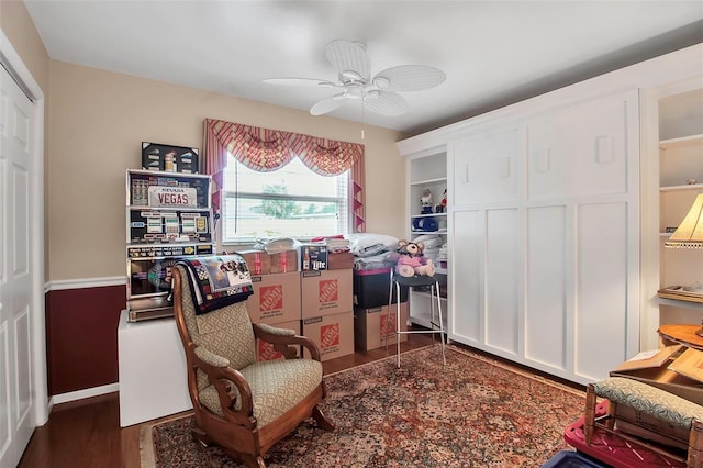 sitting room featuring a ceiling fan and dark wood-style flooring