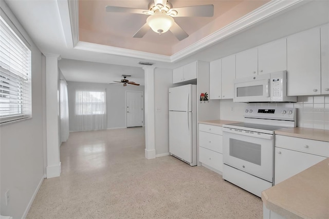 kitchen with white appliances, baseboards, light countertops, white cabinets, and a raised ceiling