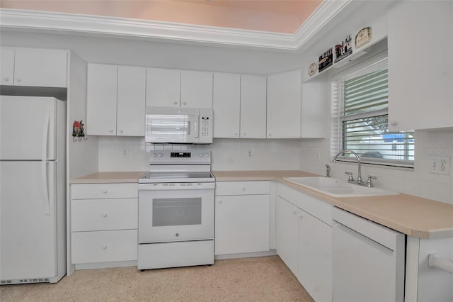 kitchen featuring white appliances, white cabinetry, light countertops, and a sink