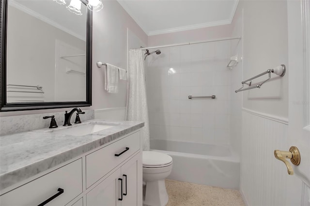 bathroom featuring vanity, speckled floor, a wainscoted wall, shower / tub combo, and toilet