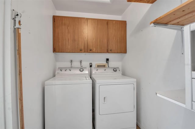 laundry area featuring separate washer and dryer and cabinet space