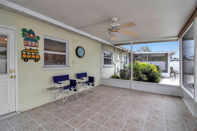 unfurnished sunroom with ceiling fan