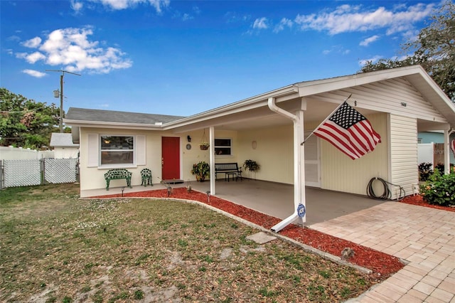 ranch-style house featuring a front lawn and fence