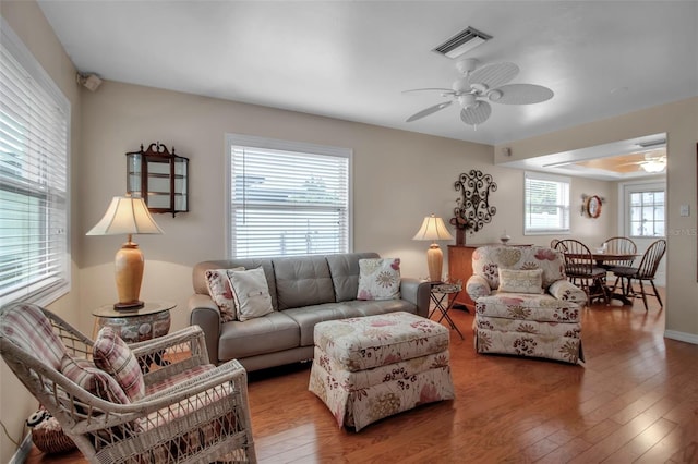 living area with hardwood / wood-style flooring, visible vents, and ceiling fan