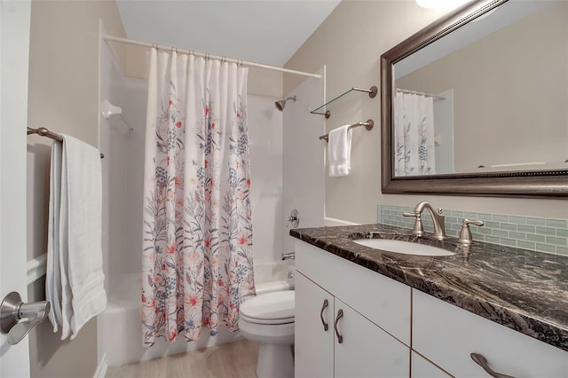 full bath with toilet, tasteful backsplash, wood finished floors, shower / bath combination with curtain, and vanity