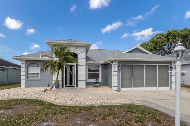 view of front of house with a garage, roof with shingles, driveway, and stucco siding