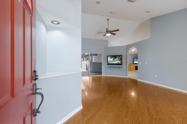 foyer featuring arched walkways, ceiling fan, wood finished floors, visible vents, and baseboards