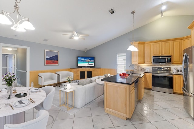 kitchen featuring stainless steel appliances, a sink, visible vents, open floor plan, and wainscoting