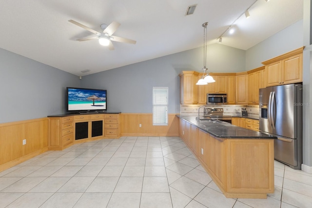 kitchen featuring a wainscoted wall, stainless steel appliances, a peninsula, visible vents, and vaulted ceiling