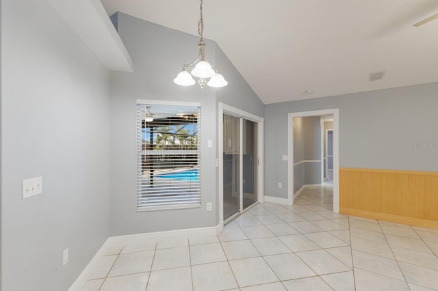 spare room featuring light tile patterned floors, lofted ceiling, and visible vents