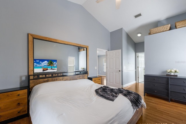 bedroom featuring visible vents, baseboards, a ceiling fan, wood finished floors, and high vaulted ceiling