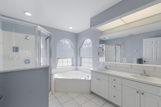 bathroom with a garden tub, double vanity, a stall shower, and a sink