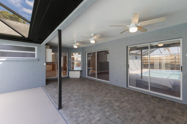 view of patio featuring glass enclosure and ceiling fan